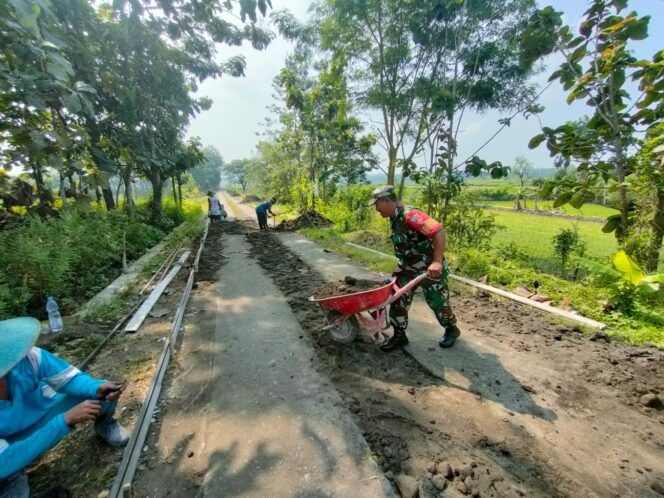 
					Upaya Menjaga Fasilitas Umum, Babinsa Bantu Perbaikan Jalan