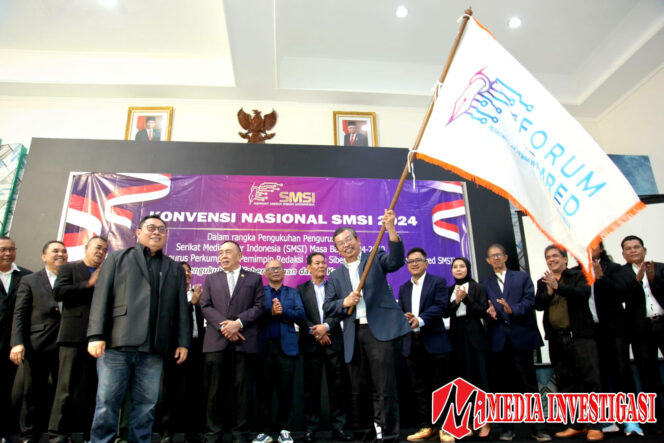 
					Pemred Askara.co Dar Edi Yoga (mengibarkan bendera) dalam Konvensi Nasional SMSI 2024. (dok. SMSI)